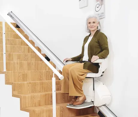 Woman sitting on the straight stairlift 
